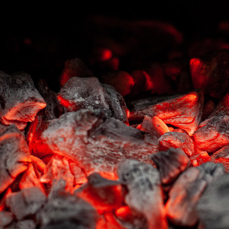 Puuhilligrillin hehkuvat hiilet ravintola Frejan keittiössä Espoossa.